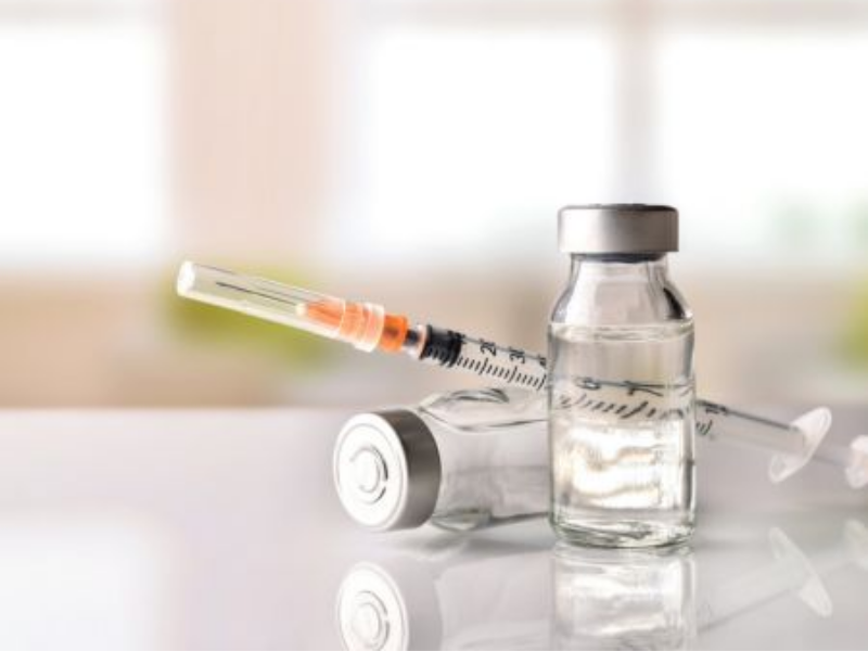 small bottle and needle with one bottle tipped over